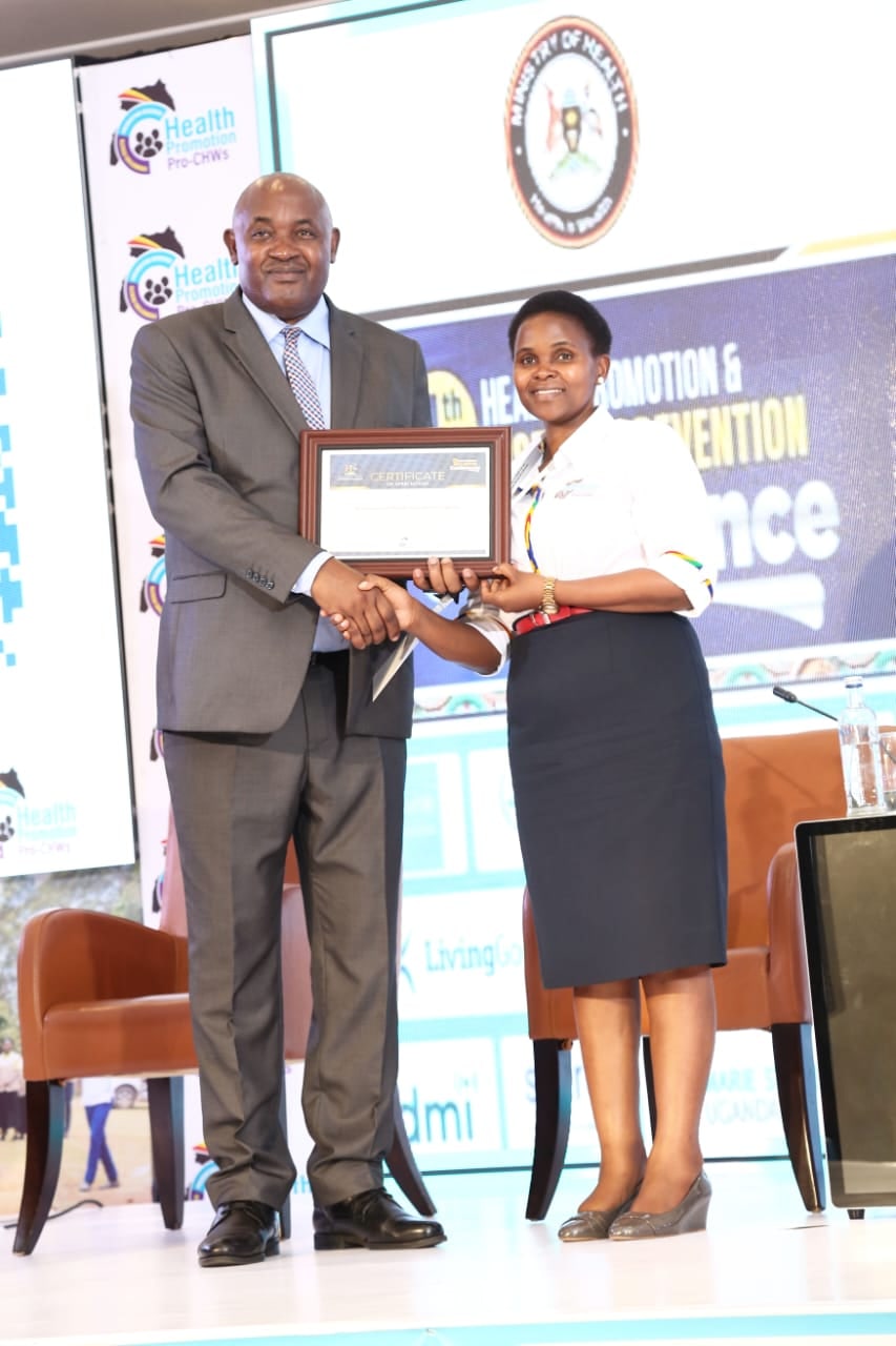 SFPHEU President Bonny Natukunda receiving recognition for the Society’s participation in the 4th Health Promotion and Disease Prevention Conference.